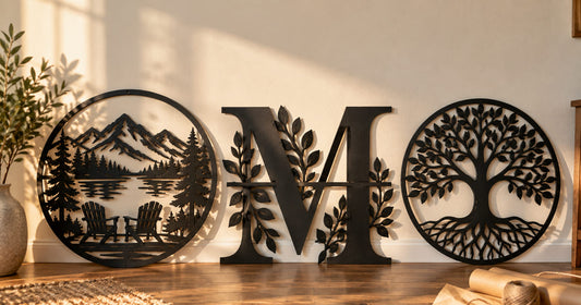 Three different laser cut steel wall signs leaning side by side against a plain wall with kraft paper and twine