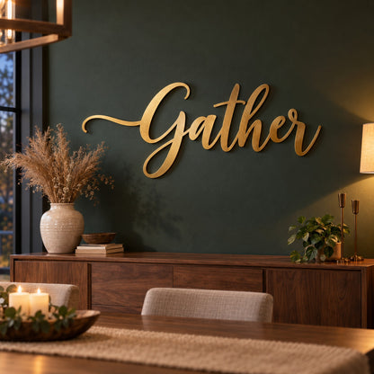 Gold laser cut steel script letters spelling Gather floating on a dark green dining room wall above a walnut sideboard