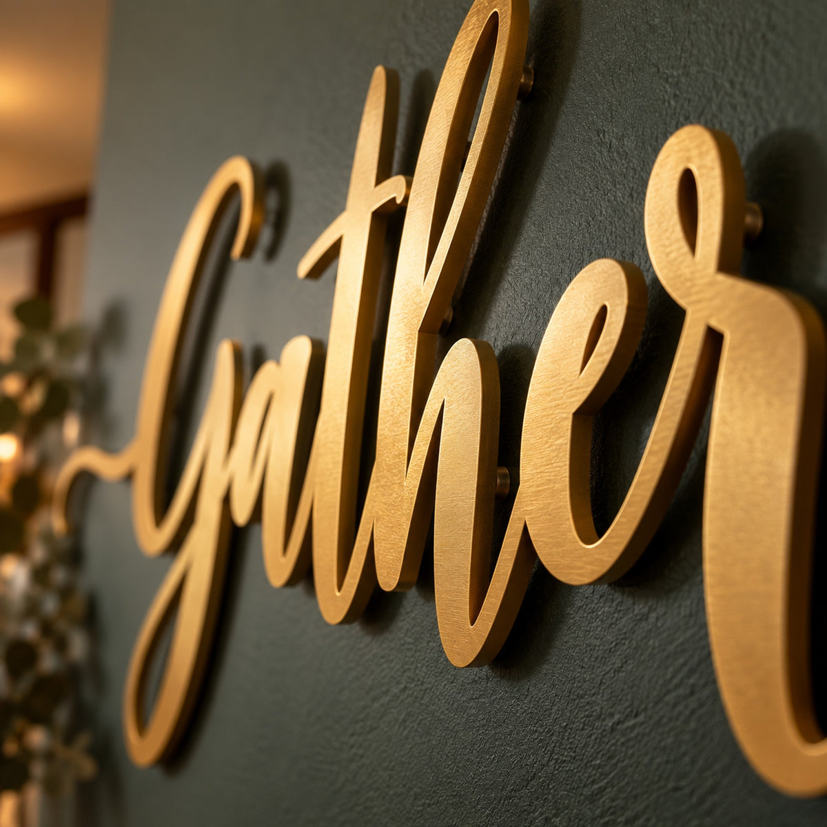 Close up of gold powder coated steel script letters showing clean laser cut edges and the floating gap to the wall
