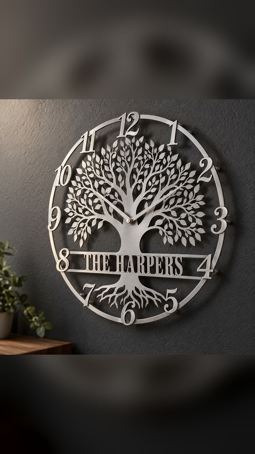 Silver personalized Tree of Life metal wall clock with script numerals and a The Harpers banner on a charcoal wall – short video